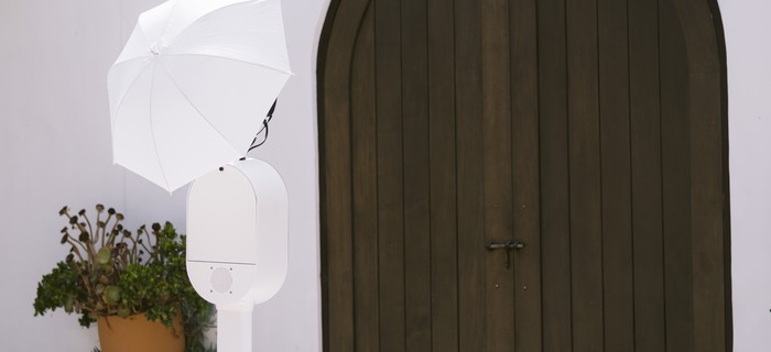 The booth set up outdoors against a white wall