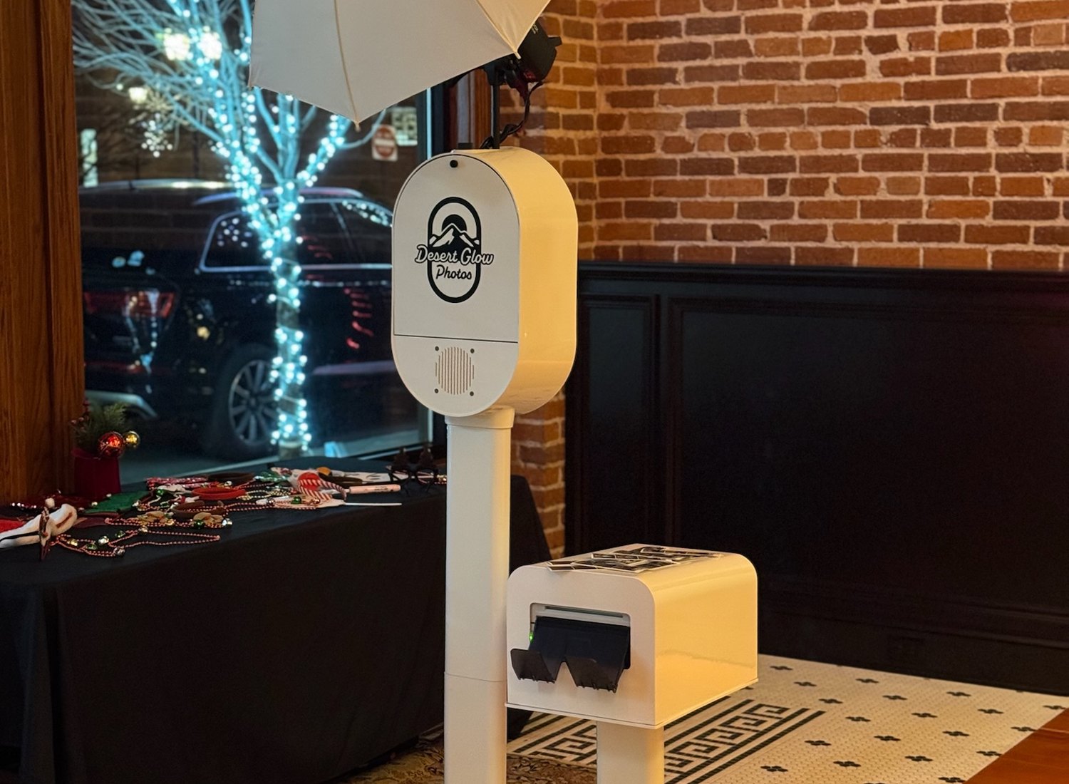 The Desert Glow Photos booth set up indoors beside a props table