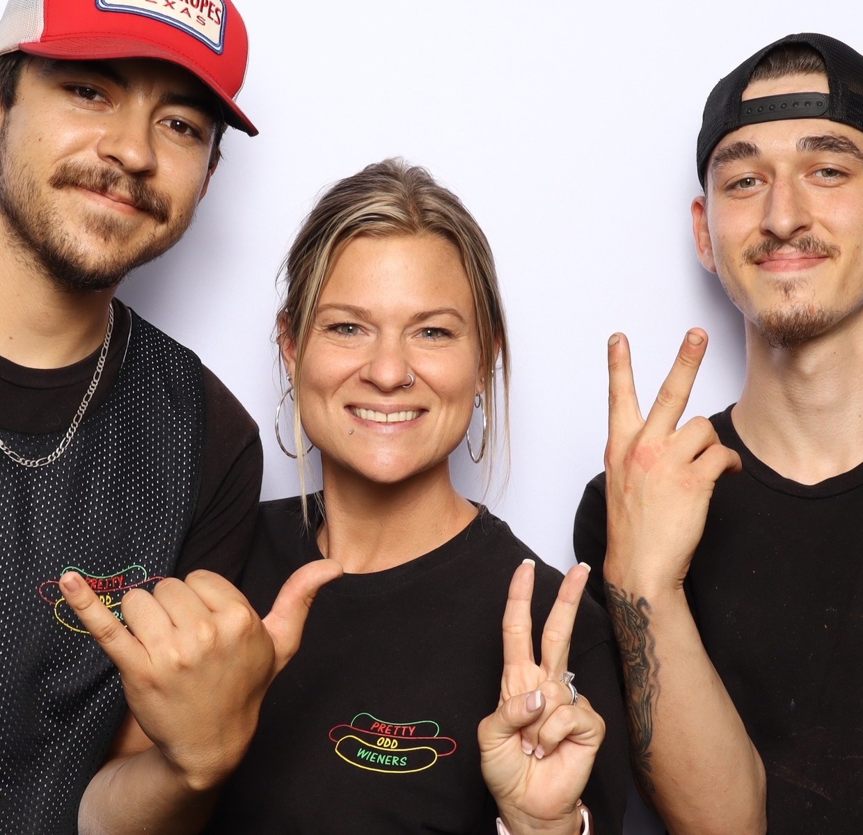 Three guests in matching branded shirts posing together in the booth