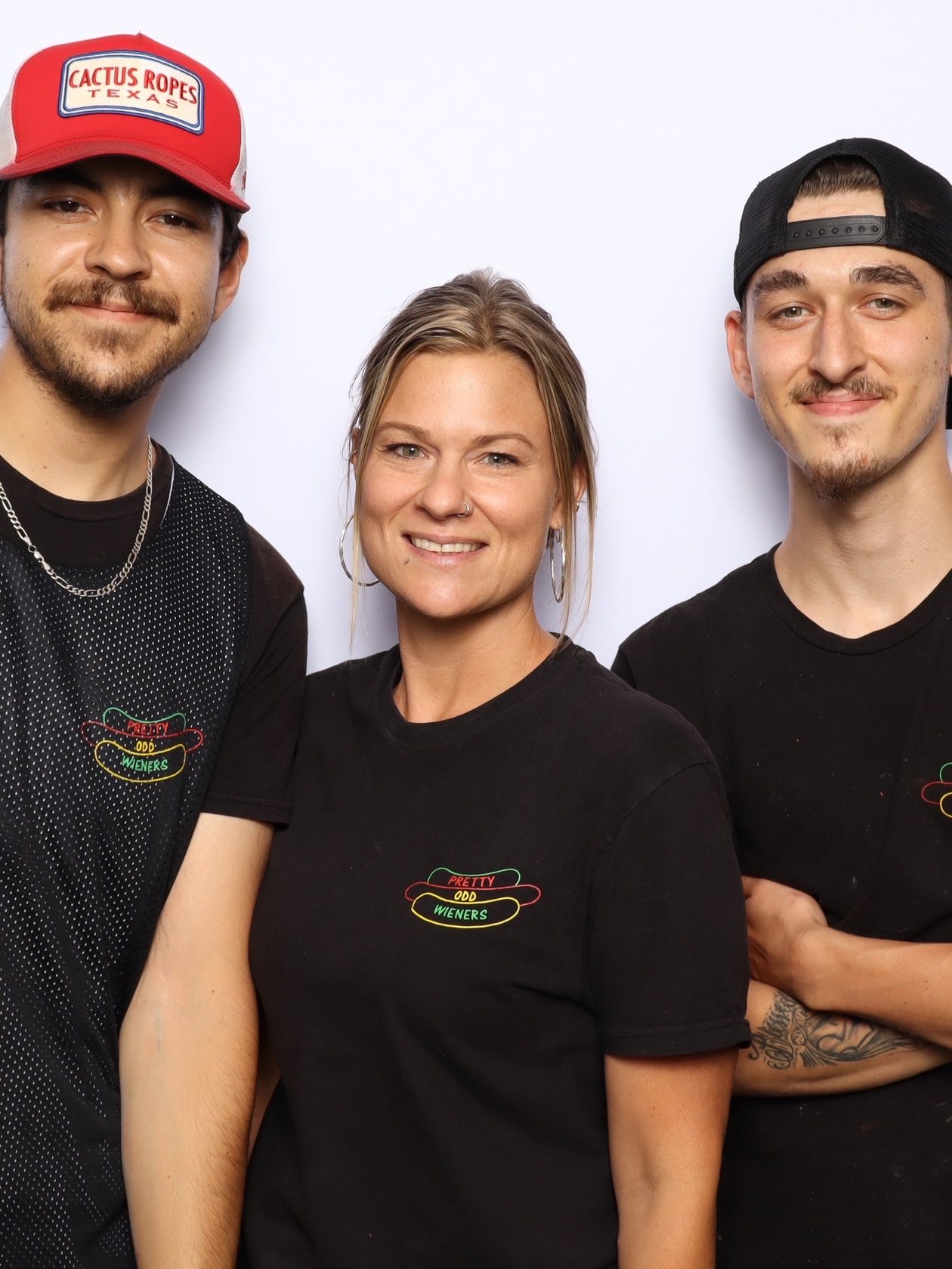 Three guests in matching branded shirts posing together in the booth