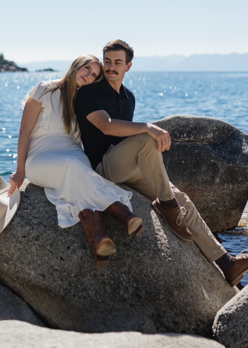 Cathren and Dyllon Ezell sitting together on the rocks beside the lake