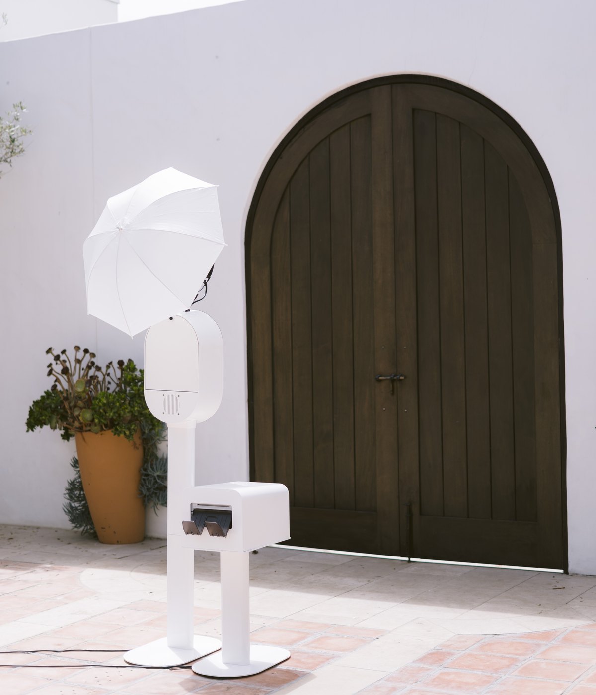 The Desert Glow Photos booth set up on a patio outside an arched wooden door